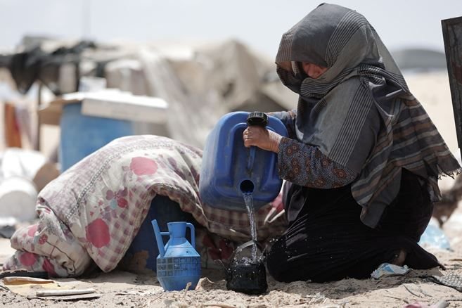 A woman is collecting water in desert